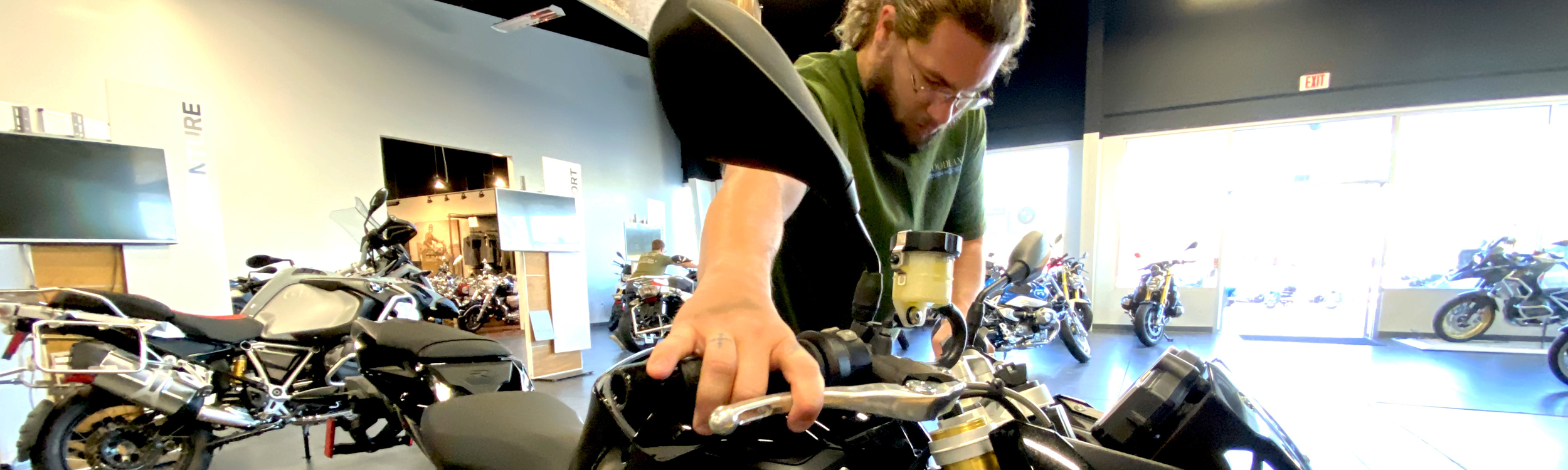 Woodlands Premium Motorcycles employee moving a bike.